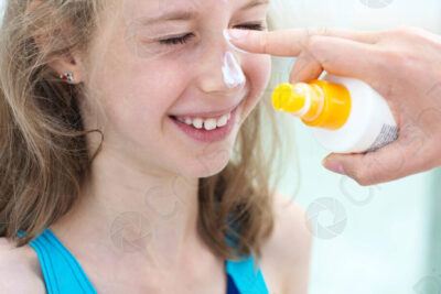 imagen de portada persona sonriente aplicando protector solar en el rostro