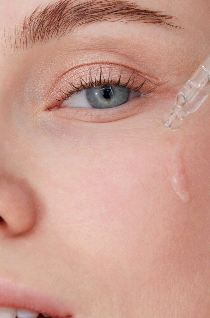 imagen de una mujer aplicando una crema en el area de los ojos para evitar las bolsas y ojeras