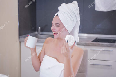 mujer joven secandose el rostro con una toalla blanca