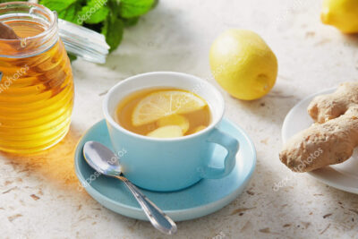 una imagen de portada con una taza de te caliente rodajas de limon y jengibre y una bufanda
