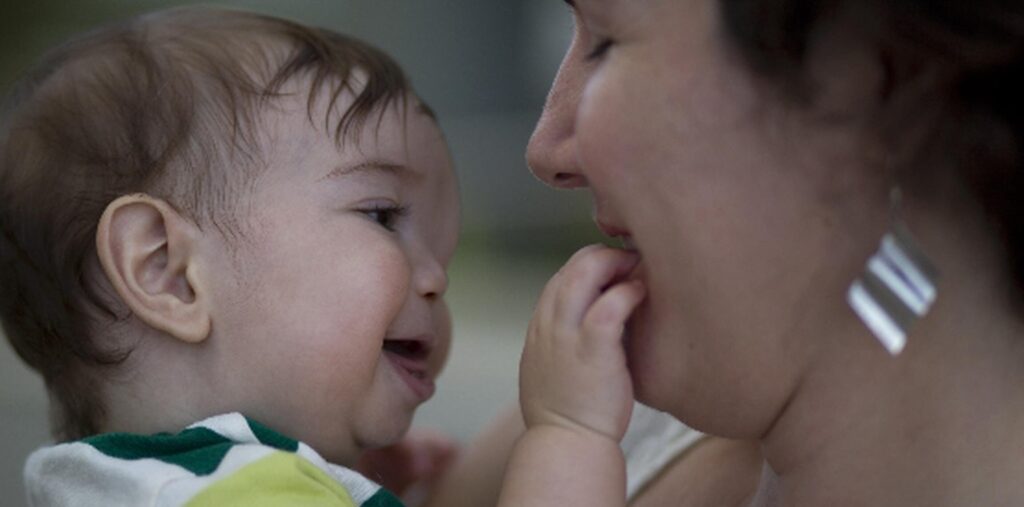 una imagen de un bebe tranquilo y sonriente durmiendo en una posicion elevada