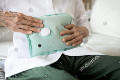 una imagen de una persona aplicando una compresa caliente en el area del ojo