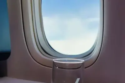 una imagen de una persona con auriculares y tapones para los oidos viajando en un avion