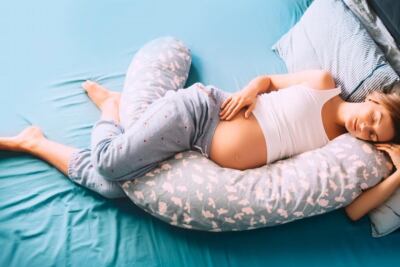 una persona durmiendo de costado con una almohada ergonomica